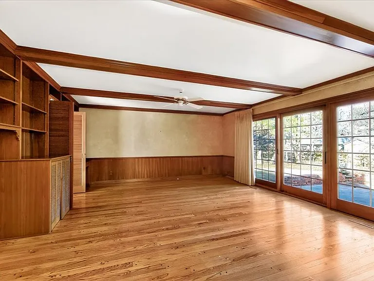 Large family room with hardwood floors and doors leading out to the patio.