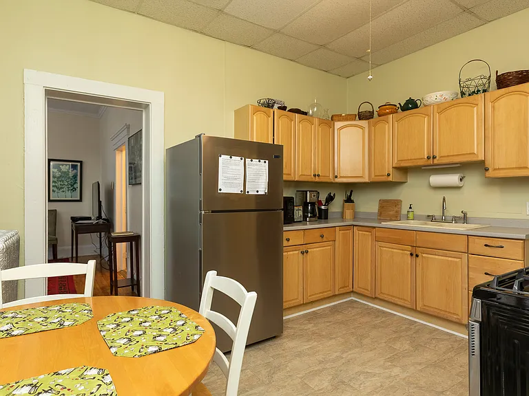 Kitchen with full-sized gas stove and refrigerator, microwave, coffee maker, toaster, plates, flatware, pots and pans.
