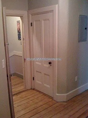 Hallwith closet and hardwood floors