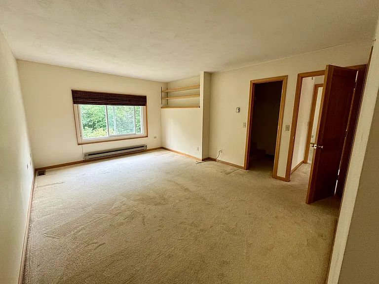 The primary bedroom with walk-in closet and built-in shelving, lovely view of the backyard