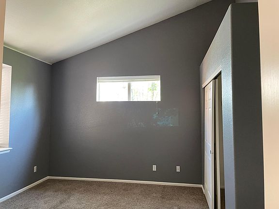 Master bedroom with vaulted ceiling and closet.