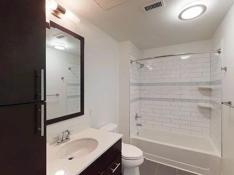 Apartment bathroom with wood-style flooring.
