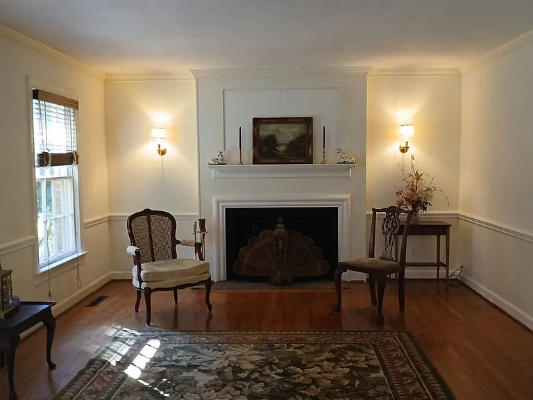 Living room includes crown moulding and chair rail and the house has pine floors.