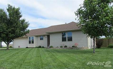 Front view of home which rests on a well manicured lot.