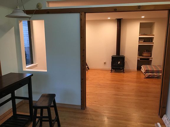 Sunroom inside front door, looking into living room and gas stove heater.