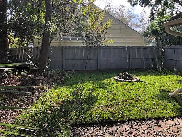 Portion of fenced back yard w/ fire pit