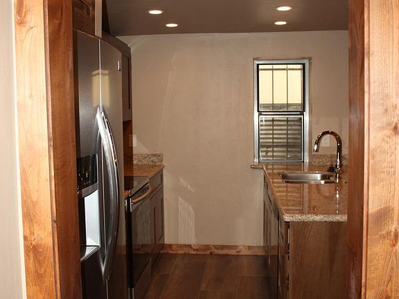 Galley kitchen with granite and stainless appliances.
