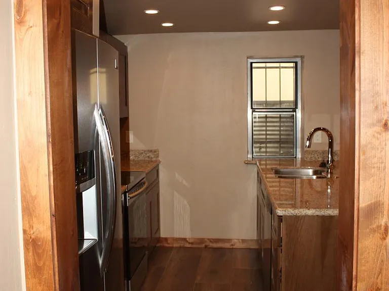 Galley kitchen with granite and stainless appliances.