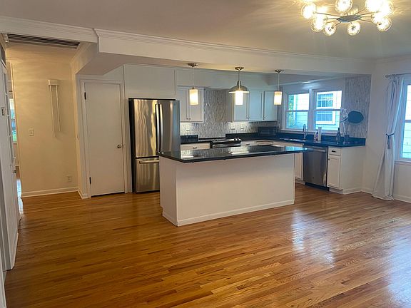 Large spacious open plan kitchen diner with granite top island and counter top fittings, stainless steel appliances.