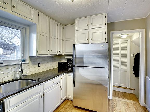 Kitchen with gas stove, granite, stainless steel, window to