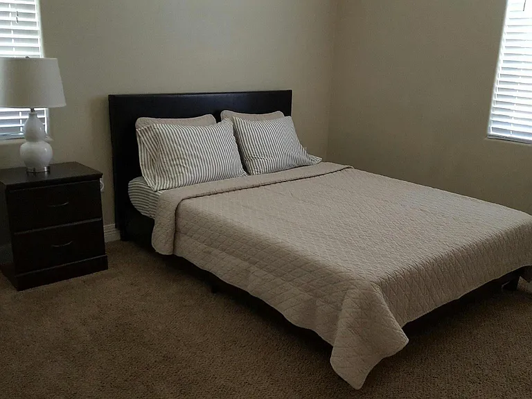 Large bedroom with carpet. Queen bed pictured for scale