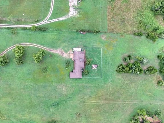 Aerial view of the home.  You can see the outbuilding, the fenced yard and the nice long drive way. More aerial views toward the end of this pictoral.