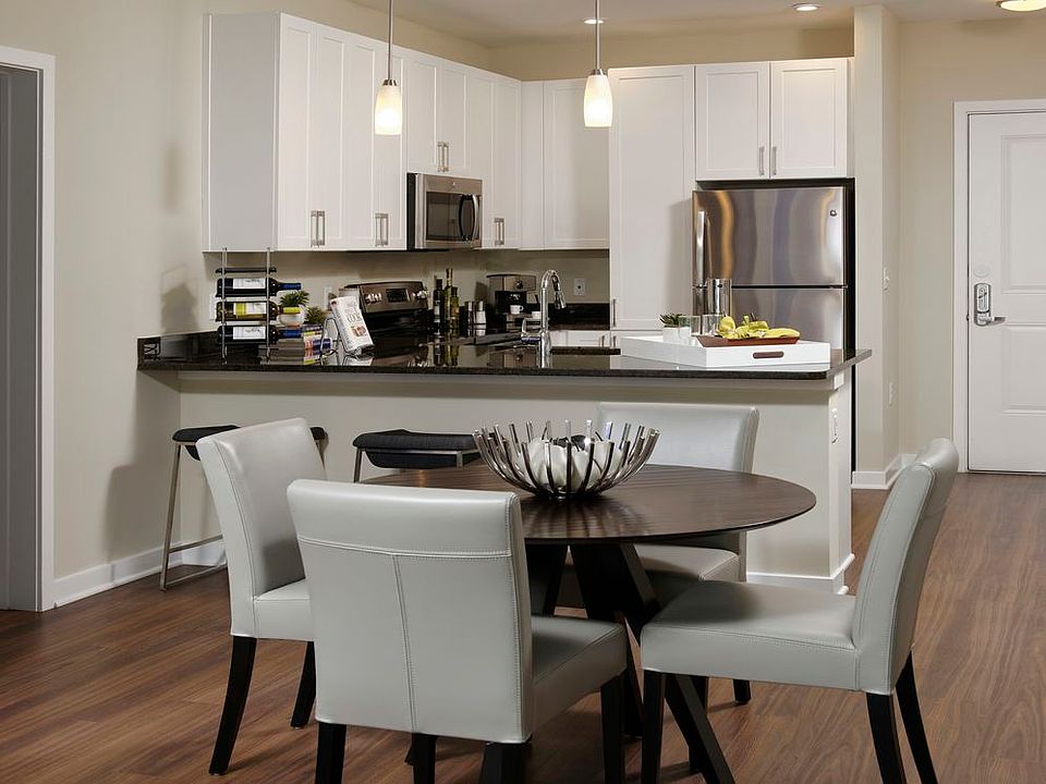Open concept kitchen and dining area with granite countertops, white shaker cabinetry, stainless steel appliances and hard surface flooring