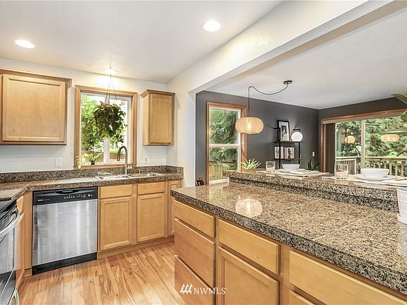 Gleaming hardwoods, granite countertops, ss appliances and an eating bar round out the kitchen