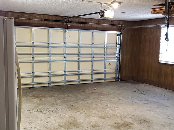 Garage with outdoor fridge along with washer and dryer.