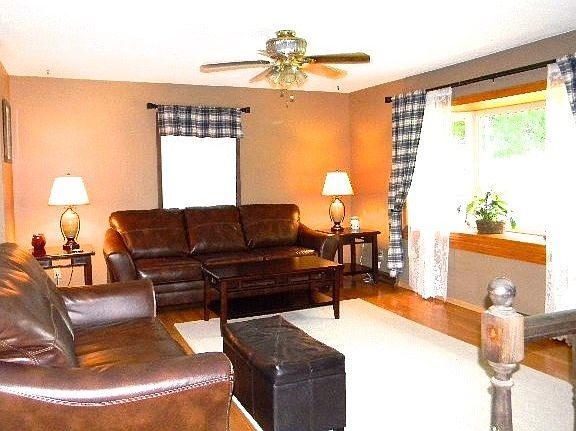 Hardwood flooring featured in spacious living room.