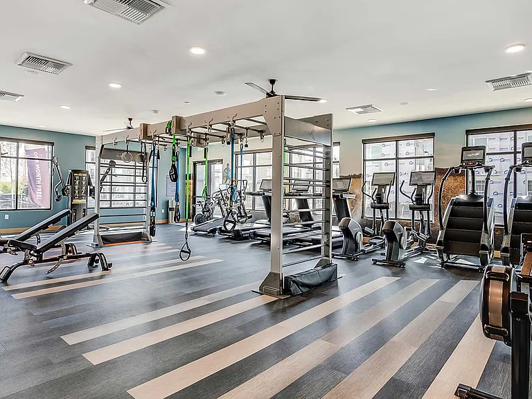 Crush your wellness goals with a spacious fitness studio featuring cardio machines, functional training zones, free weights, and strength equipment just steps from home.