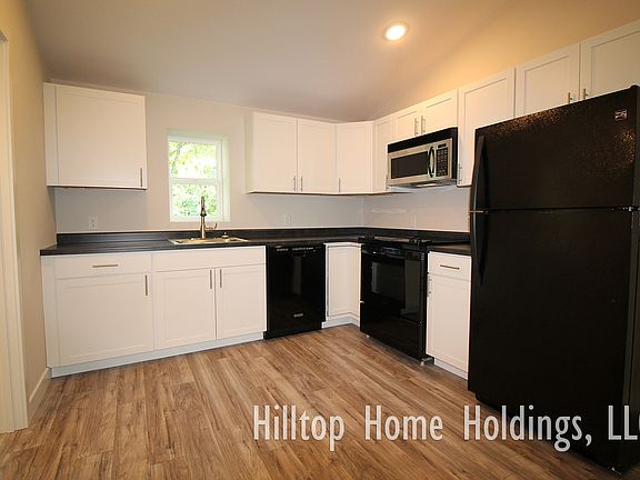 Kitchen is equipped with a dishwasher, refrigerator, range, and microwave.