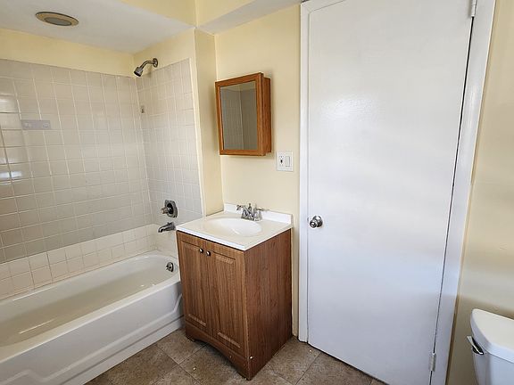 Big bathroom with a full tub and medicine cabinet plus vanity.