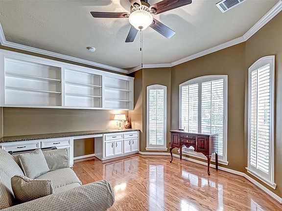 On the right of the entry is a large study with built-ins, crown moulding and hardwood flooring. The study connects to the bedroom suite.
