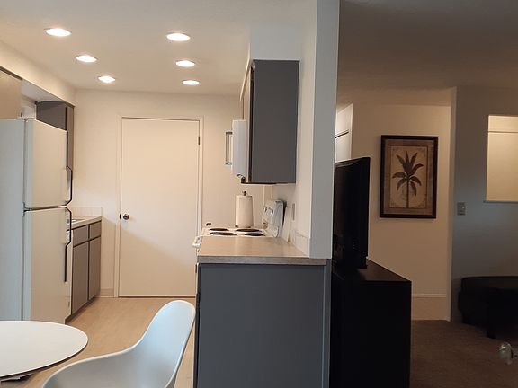 Standing at garage door looking into unit. Living room on right, kitchen on left, in unit washer and dryer behind closed door in kitchen.
