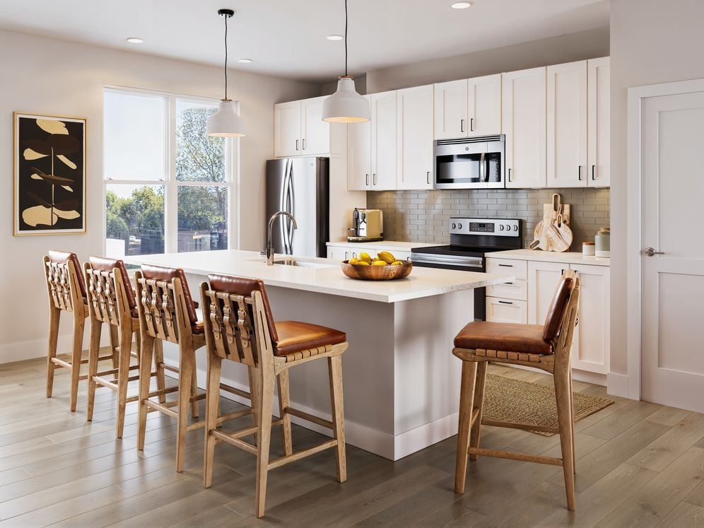 Townhome kitchen with white cabinetry, tile backsplash, stainless steel appliances, pendant lighting, and hard-surface vinyl plank flooring (Rendering)