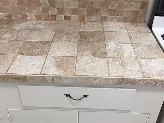 Kitchen close-up of cabinet and tile countertops/backsplash.