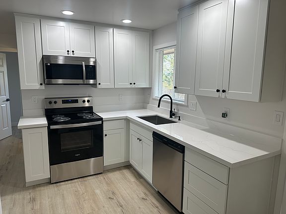 Brand new kitchen appliances including stove, microwave, dishwasher, refrigerator, and 16 Gauge stainless steel sink. Cabinets are slow close with brand new hardware and quartz countertop + backsplash