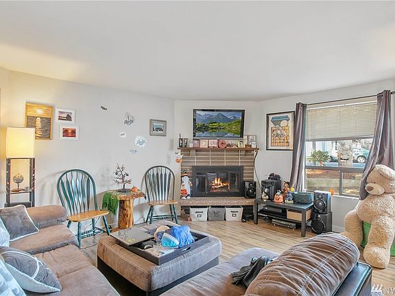 Family room with large windows and newer laminate hardwood floors.