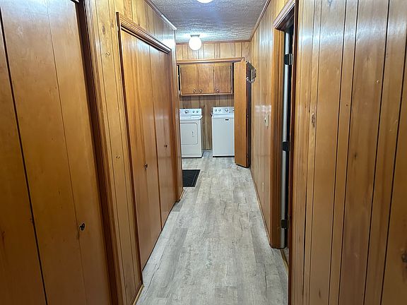 Long hallway with large storage closets on left side. Side entry door that leads to driveway.