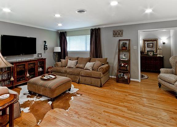 Living room with original hardwood floors, recessed lighting, crown molding.