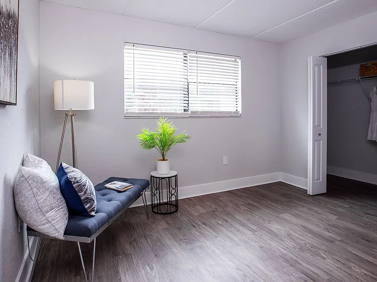 Spacious bedrooms at featuring a large window for natural light, sleek wood-style flooring, and a generously sized closet, offering both style and functionality for your everyday living.