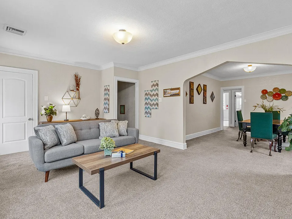 Spacious living room with a comfy couch, flowing seamlessly into the inviting dining area.