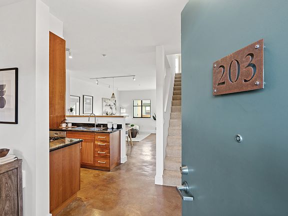Entrance to #203 on second floor. Stained concrete floors on main level and upstairs carpeted bedroom.