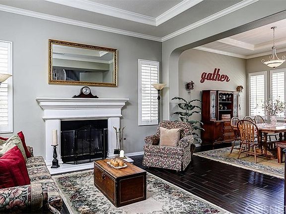 LIVING ROOM: Wood floors, coffered ceiling, dramatic arched entry to dining room
