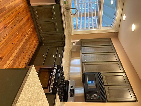 Kitchen dishwasher, sink, cabinets, counters, microwave, stove and peninsula