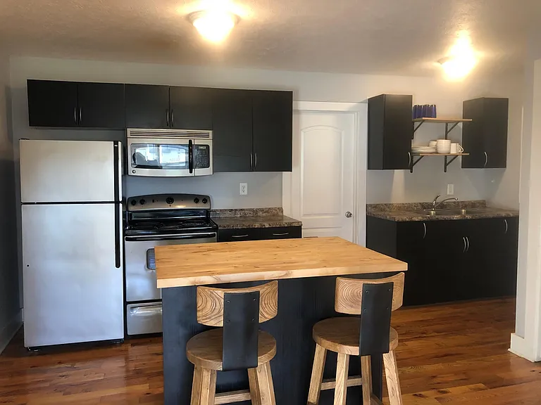 Kitchen with microwave, electric range, dishwasher and butcher block countertop island