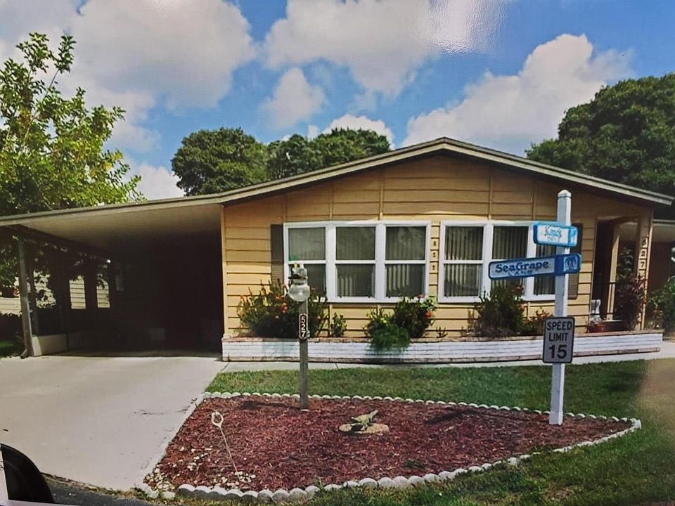 Front view of home. Carport/driveway parking. Enter home thru lanai (off of carport) or front entrance into Living Room. Inground sprinkler system. Lawn cutting provided by Country Lakes.