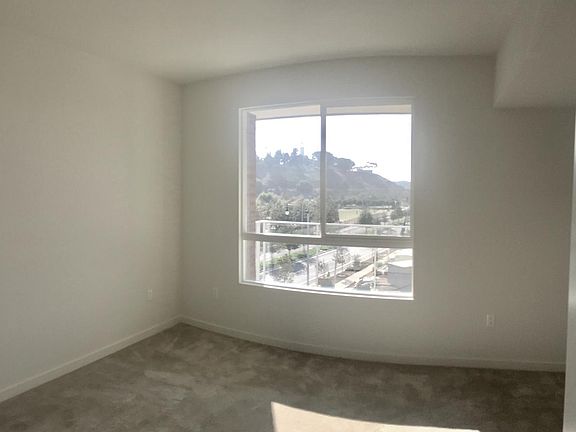 large bedroom window looks out onto the patio, and off into