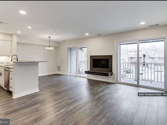 Bright open-concept living area with updated flooring, fireplace, and direct access to the private balcony.