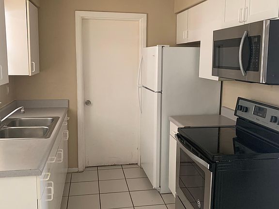 Galley Kitchen leading to utility room with washer dryer hookup