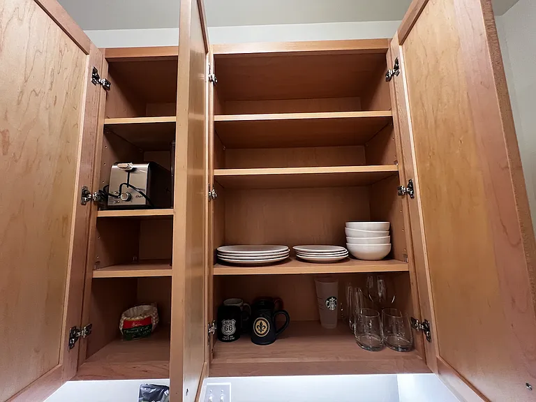 Toaster and dishes in cabinets, with room for your things.