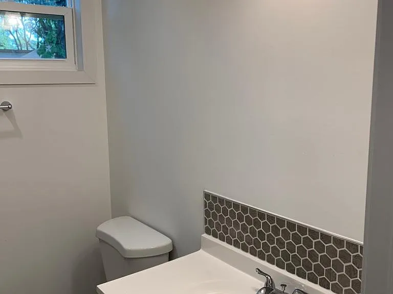 Spotless bathroom in excellent condition featuring a sink, toilet, and storage drawer for essentials. Lakeland, FL