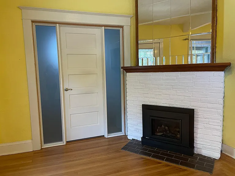 Gas fireplace in living room and door to office/unofficial bedroom