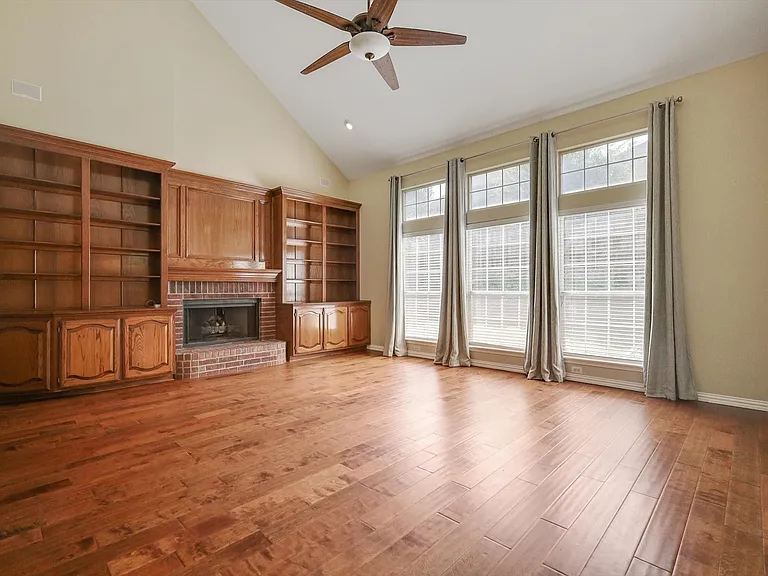 Soaring ceilings, wood flooring, built-ins, fireplace and an abundance of light define this expansive living space
