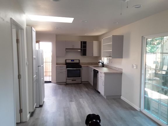 Kitchen Dining area with front entry door and back sliding door to right. Going out to back yard and small deck.