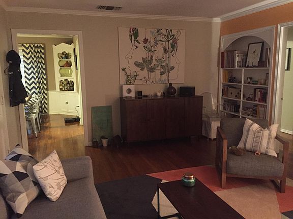 Living room and view into dining room. Built in bookshelves in the living room, original hardwood floors, central heat and air, and lots of natural light.