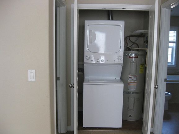 New washer and dryer behind door in hall way.