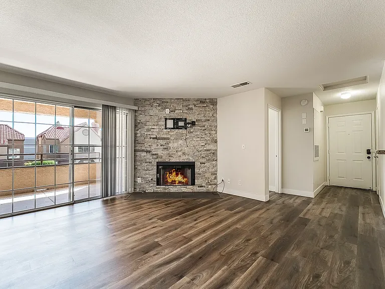 Living Room with Travertine Stone Surround for Gas Fireplace. TV Mount ready for your tv. Sliding Glass Doors to Private Balcony and Storage Closet.