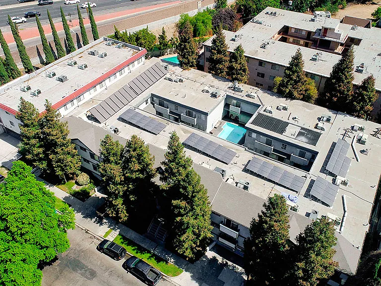 Aerial drone image of building with view of solar panels.